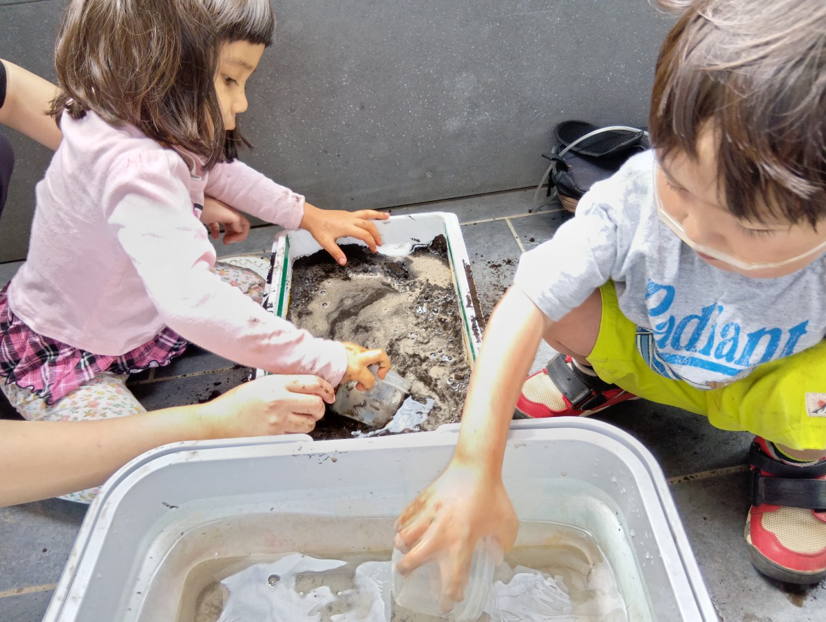 子どもたちは発泡スチロールの中に土と水を入れている