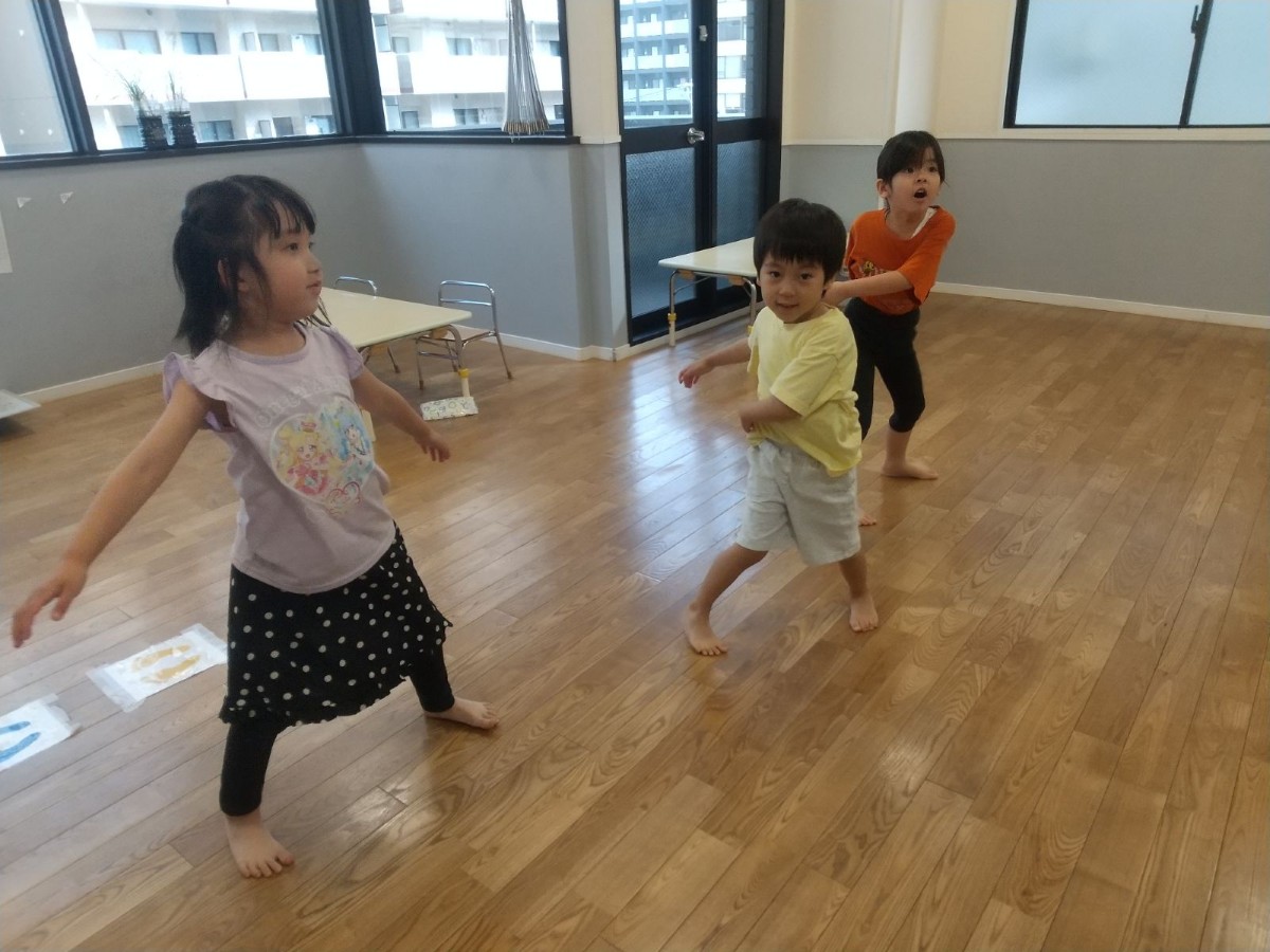 室内では3人の子どもたちが手を左右に振って準備体操をしている