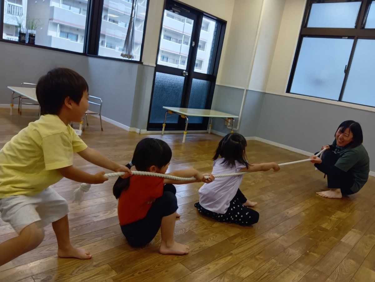 大人と子どもたちで綱引きをしている