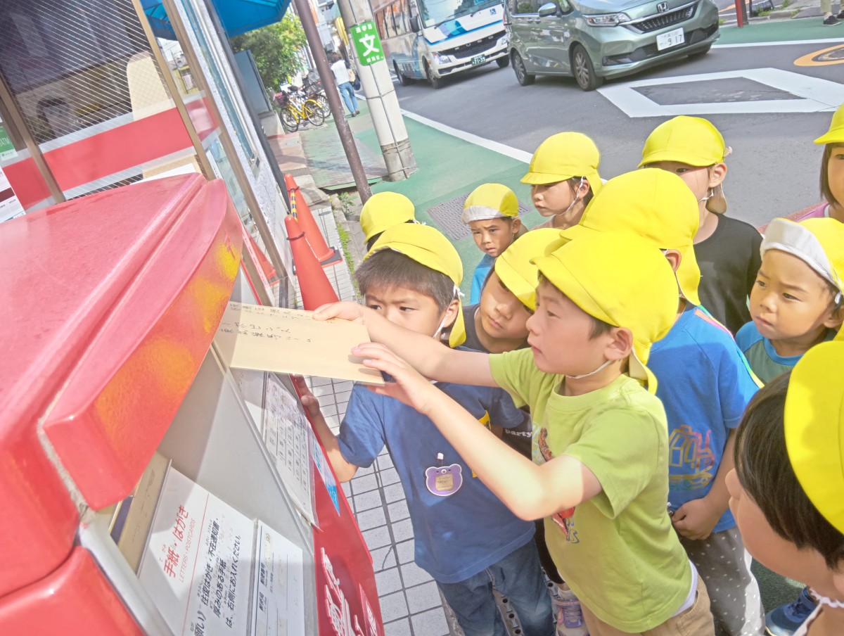子どもたちは、郵便ポストに園宛ての手紙を投函しようとしている