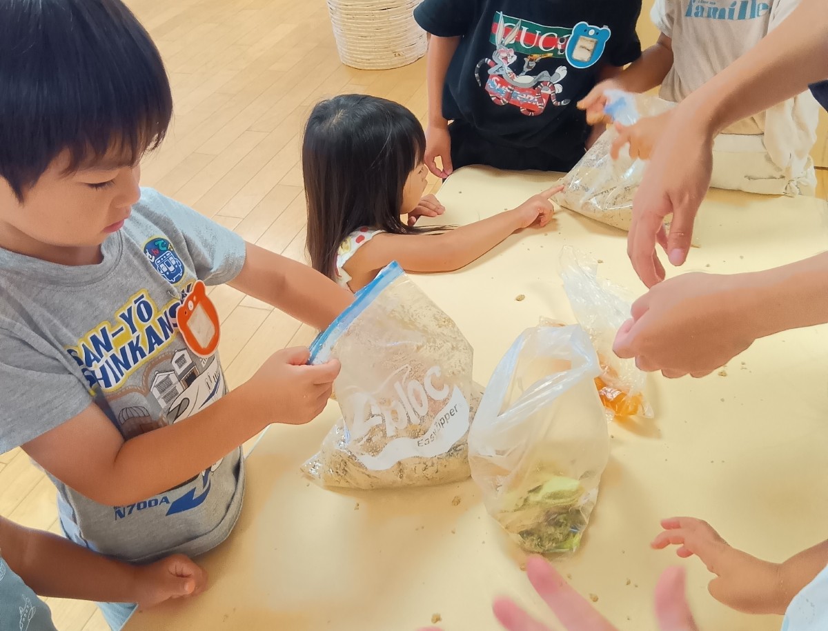 子どもたちはジッパー付きポリ袋の中に野菜を手を入れてぬか床をかき混ぜたり、袋の外側から指先で感触を確かめたりしている
