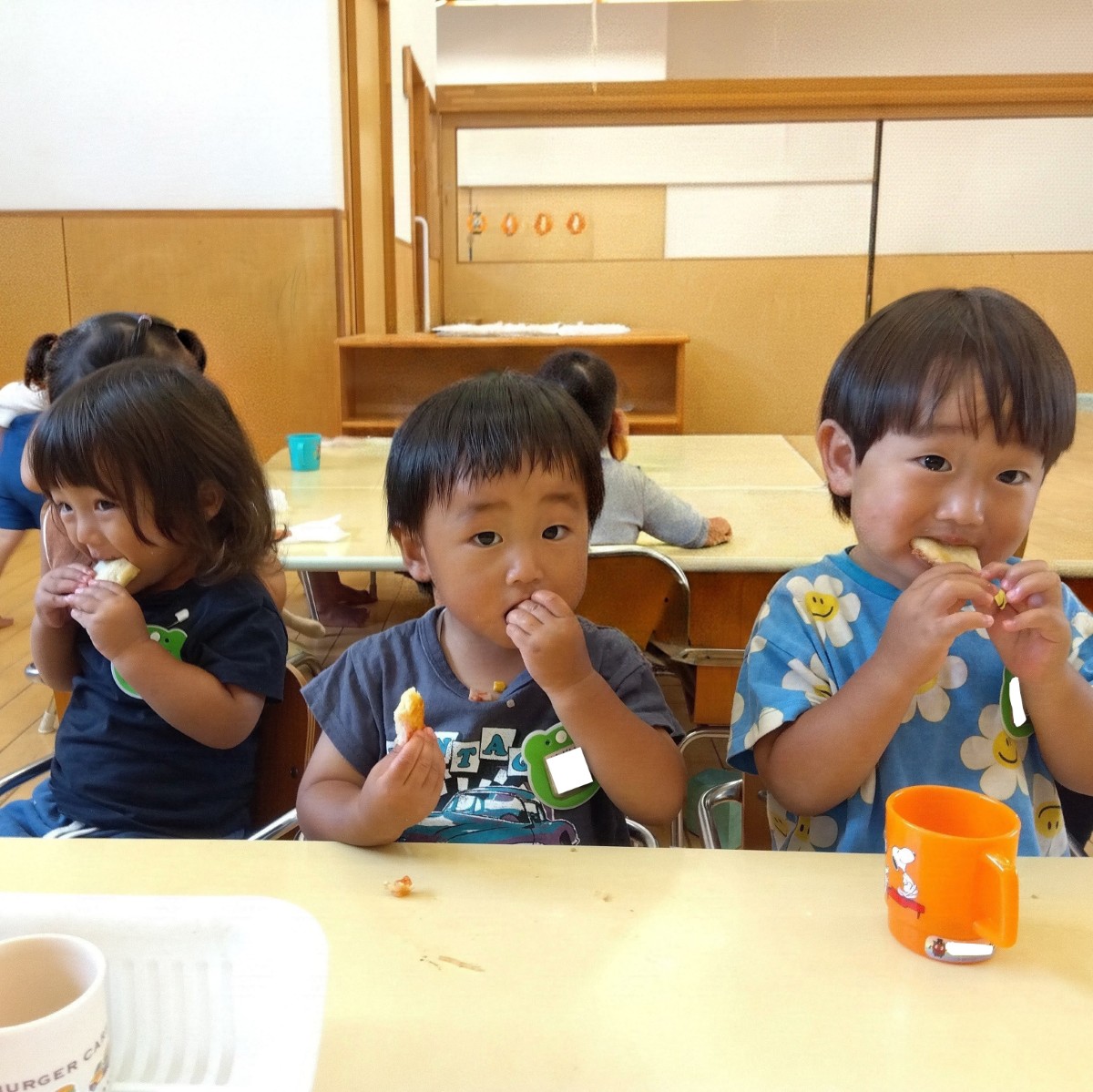 子どもたちは、手でピザを持って食べている