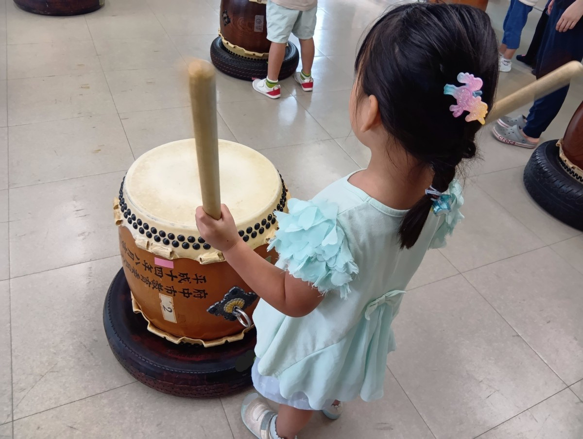 子どもたちは太鼓の前に立ち、バチで太鼓を叩いている