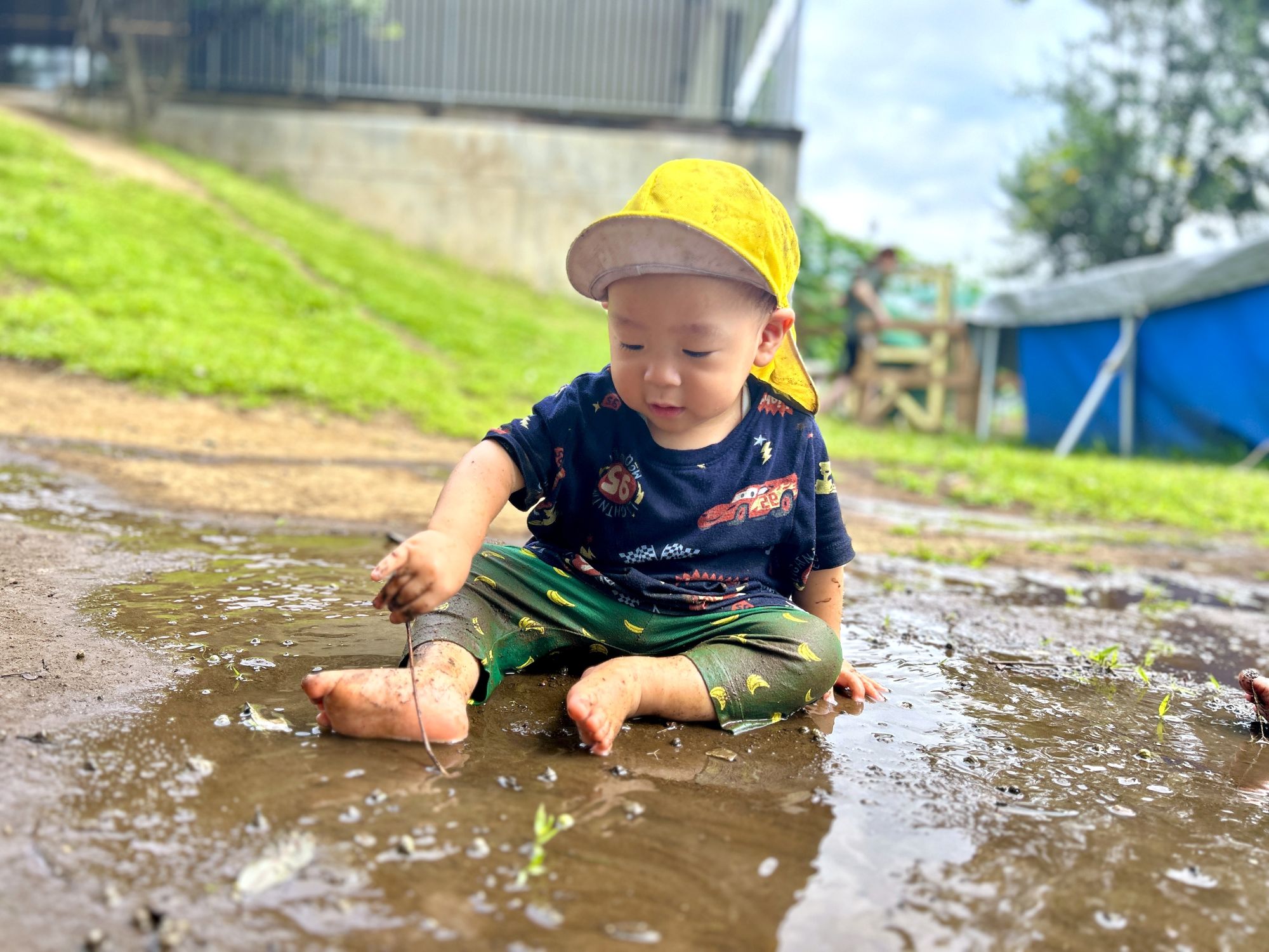 水たまりの中で遊ぶ0歳児
