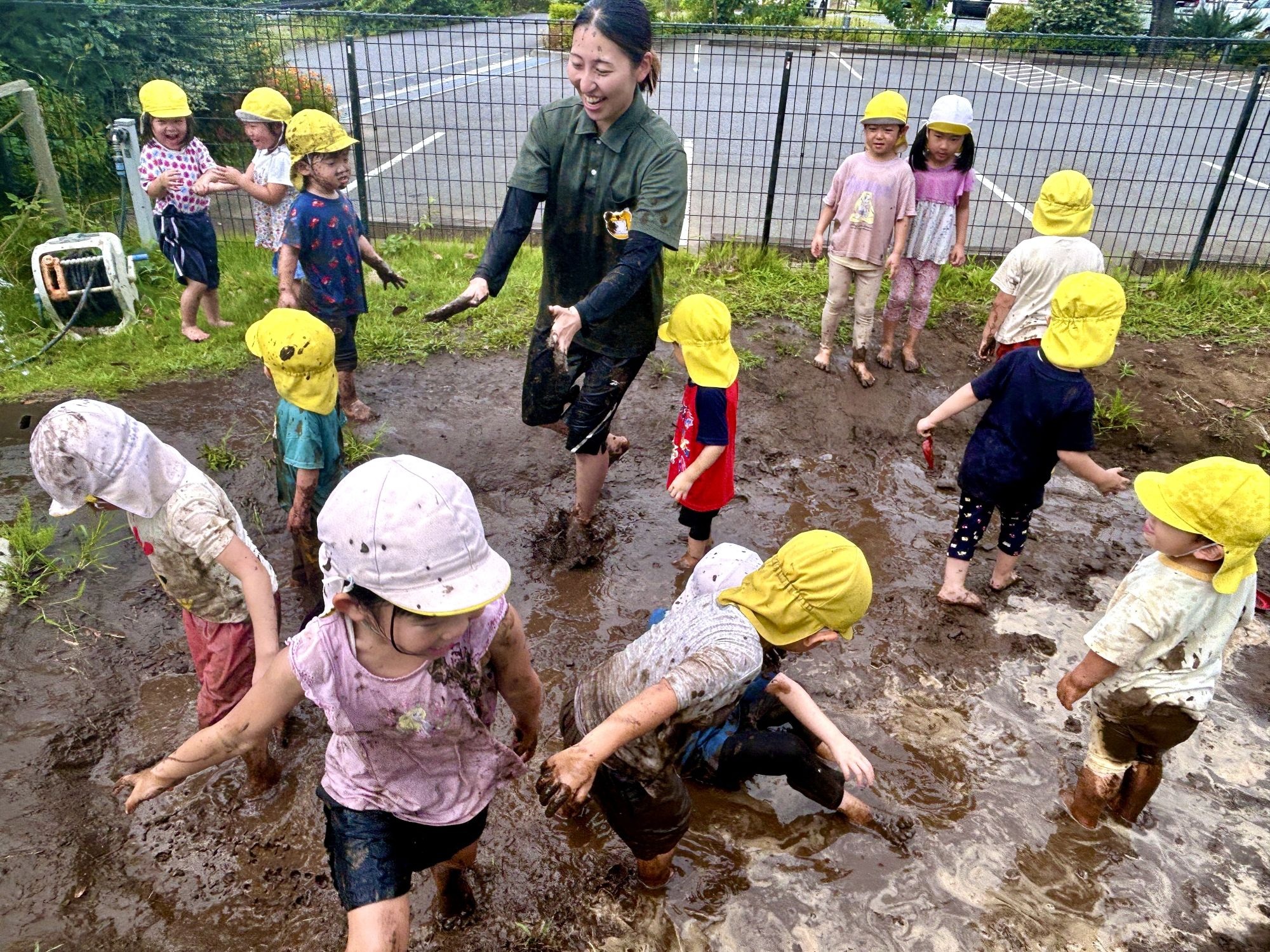 子どもと共に泥遊びを楽しむスタッフ