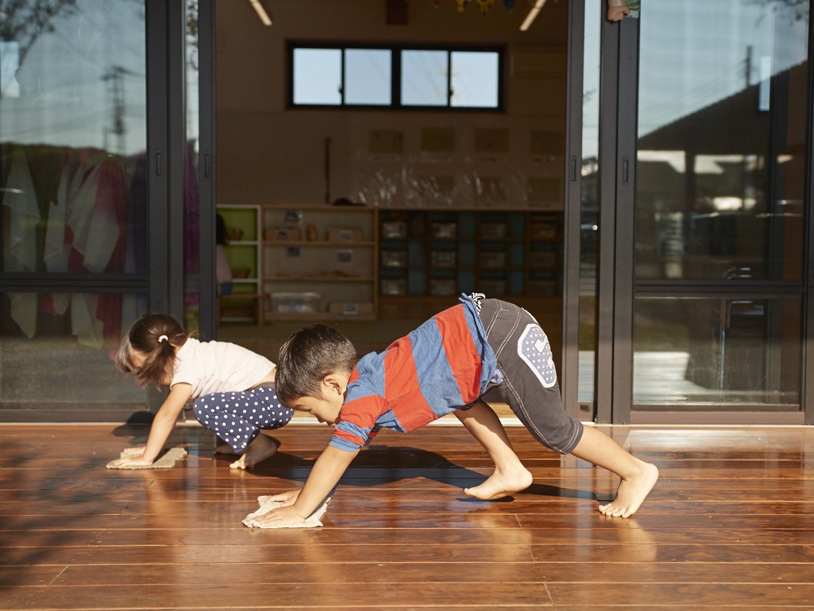 縁側で雑巾がけをする子どもたち