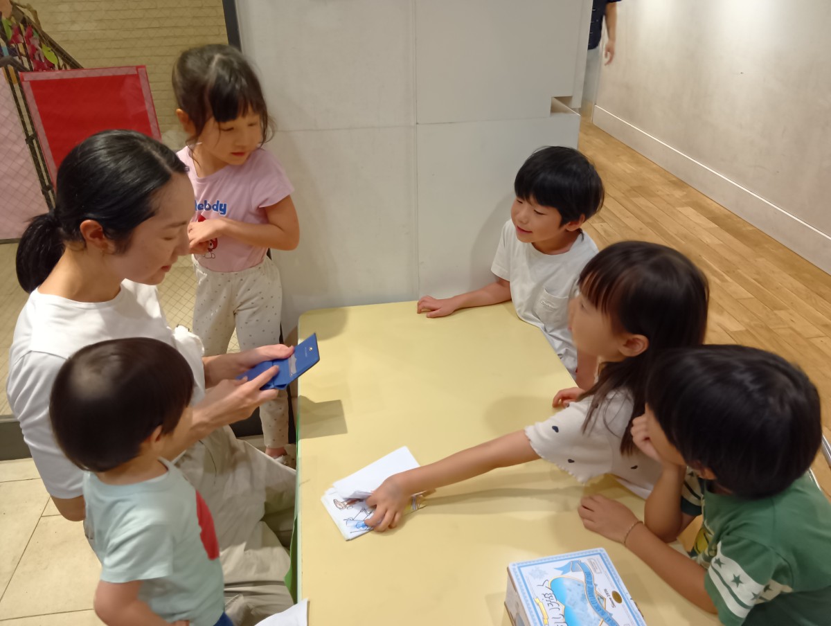 大人と子どもたちが机を囲んで話し合っている
