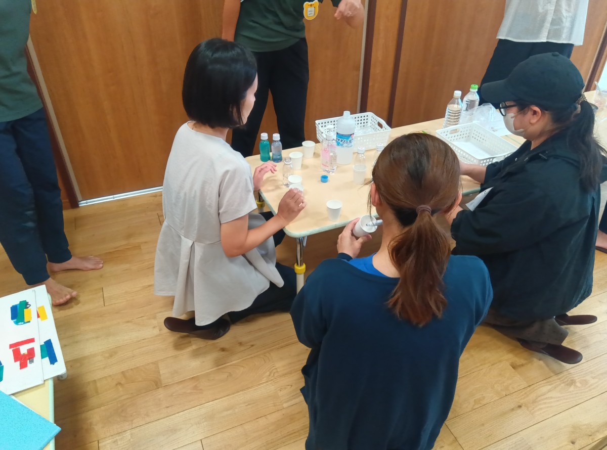 3人の大人が座ってセンサリーボトルを作っている