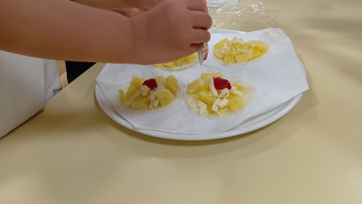 餃子の皮の上に、じゃがいも、チーズ、ケチャップが載っている
