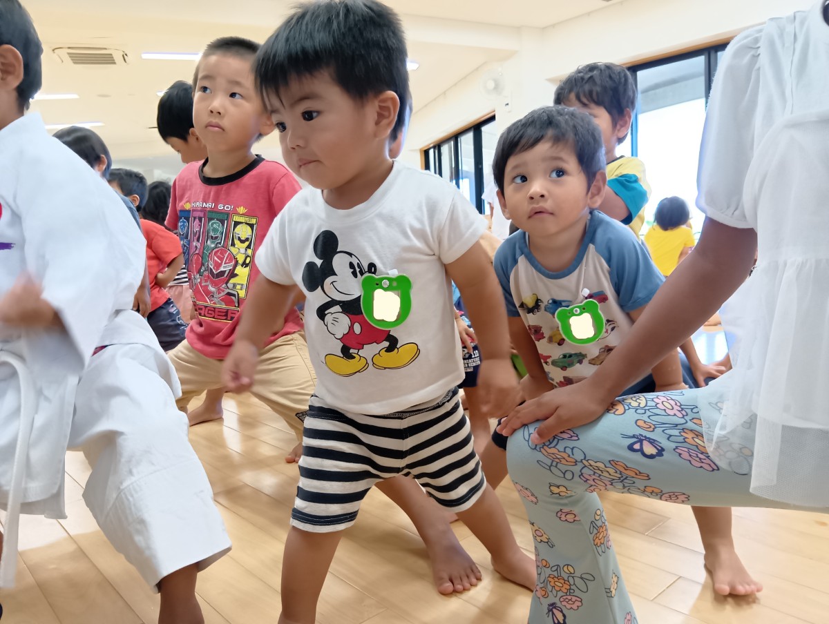 子どもたちが脚を大きく開いてスクワットポーズをとっている
