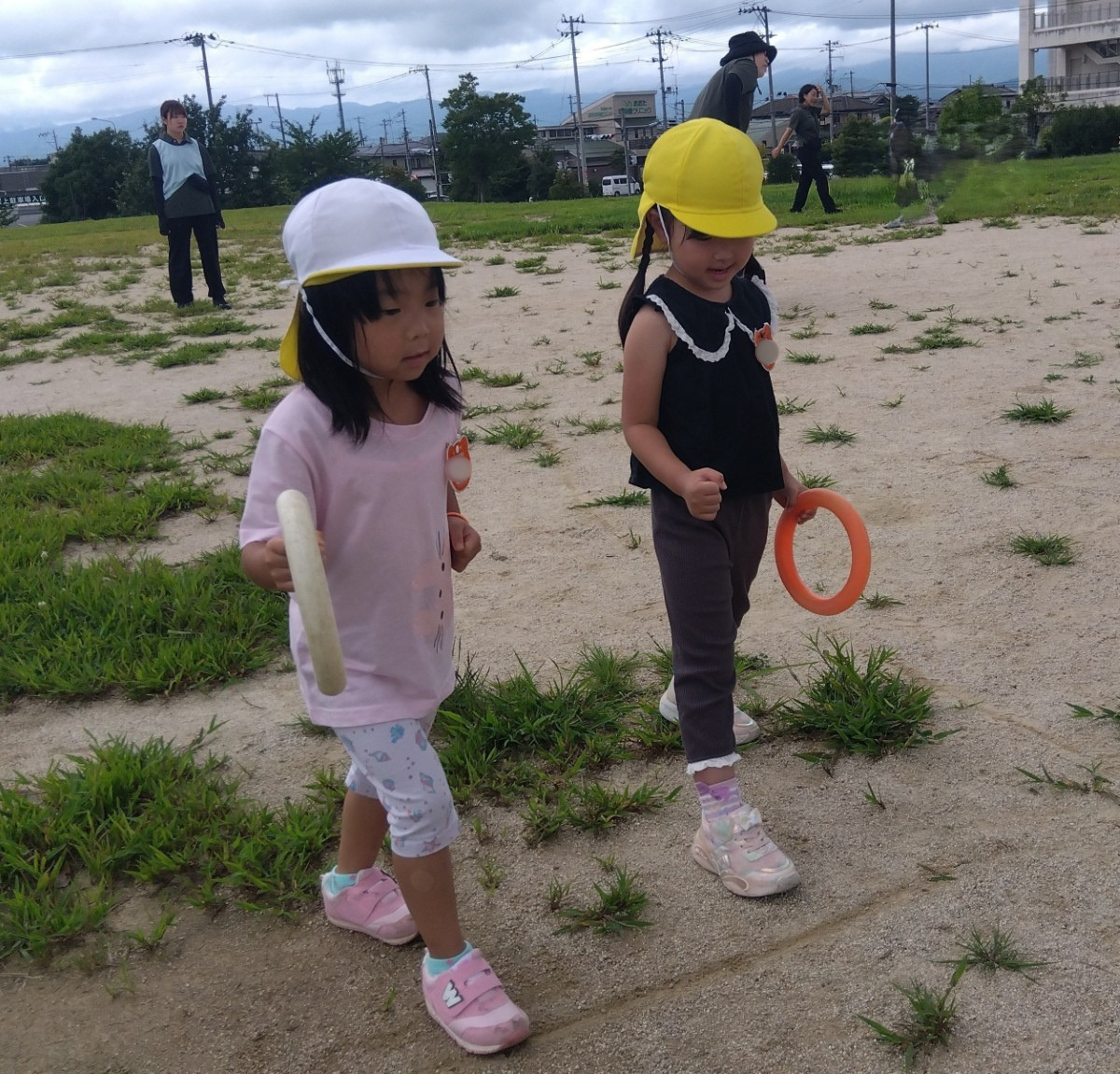 二人の子どもがバトンを手に持ち、スタートの用意をしている