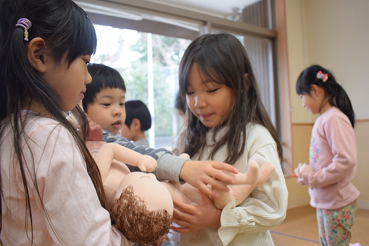 胎児人形を抱っこする子どもたち