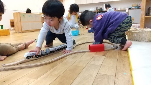 電車のおもちゃで遊ぶ子どもたち