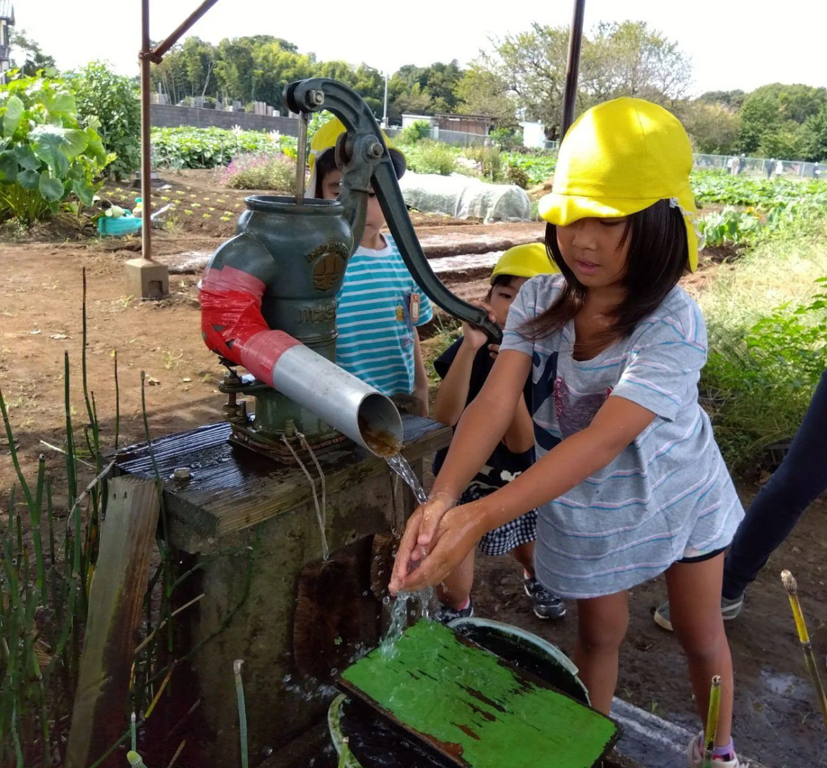 井戸水で手を洗う子ども